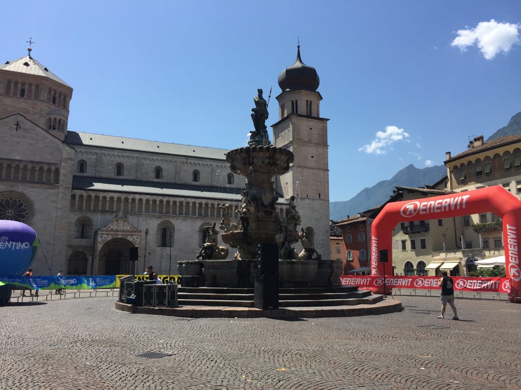 La piazza centrale di Trento sotto il sole cocente all'arrivo dei ciclisti della Moserissima. Sulla destra il pallone di Enervit, uno degli sponsor della cicloturistica