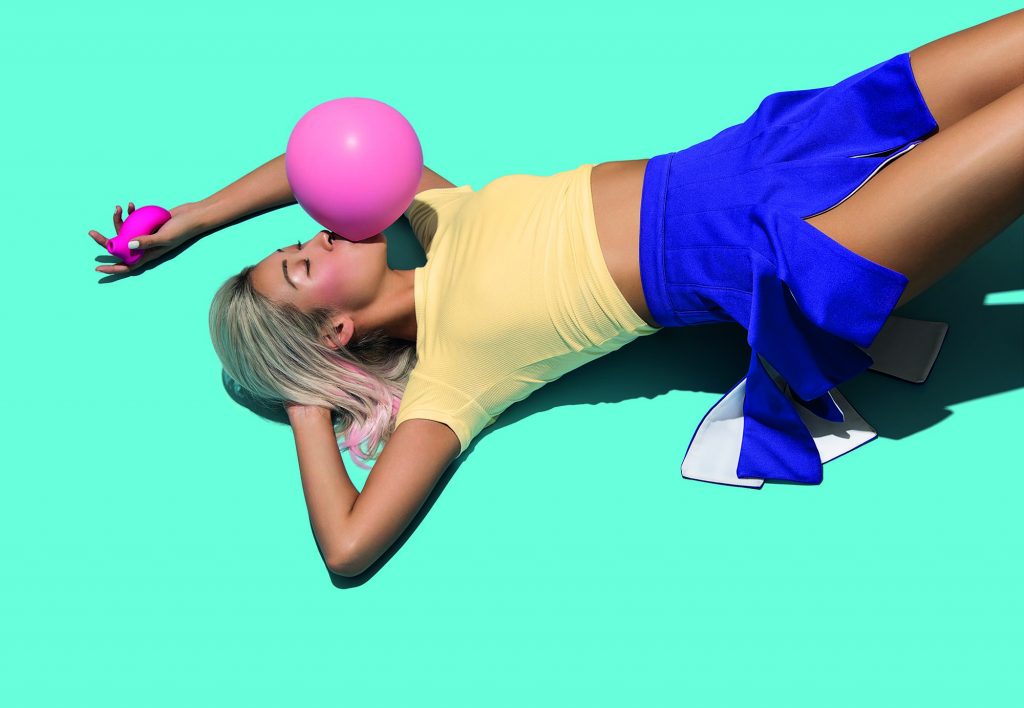 La campagna pubblicitaria di Pelo con una ragazza che fa un palloncino con una cicca e sdraiata a terra ha un viso compiaciuto, mentre tiene in mano Sona