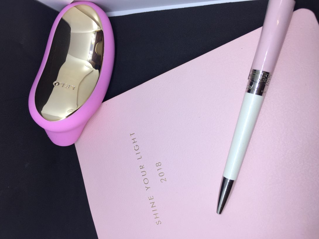 Sona è appoggiato sul tavolo accanto a un'agenda rosa e a una penna dello stesso colore